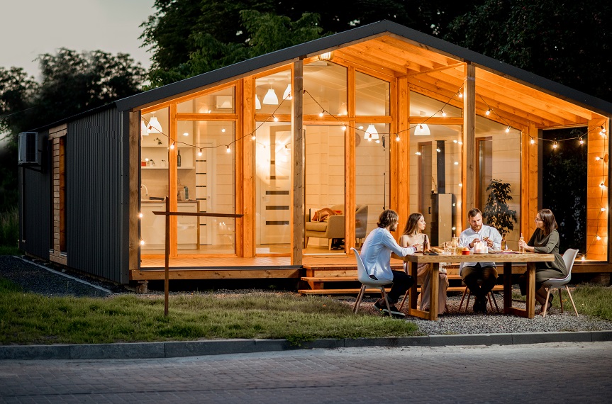 Backyard of the house with people sitting at the table